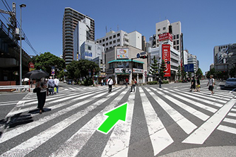 関内駅北口交差点を赤い看板のカラオケ店の方へ渡ってください。